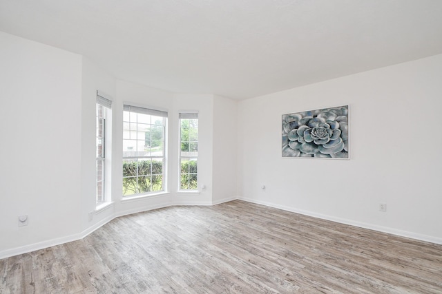 unfurnished room featuring baseboards and wood finished floors