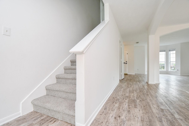 stairway with baseboards and wood finished floors