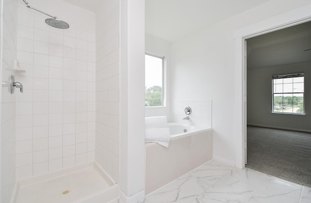 full bath featuring baseboards, a stall shower, a garden tub, and marble finish floor