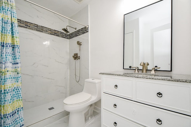 bathroom featuring toilet, a tile shower, marble finish floor, and vanity