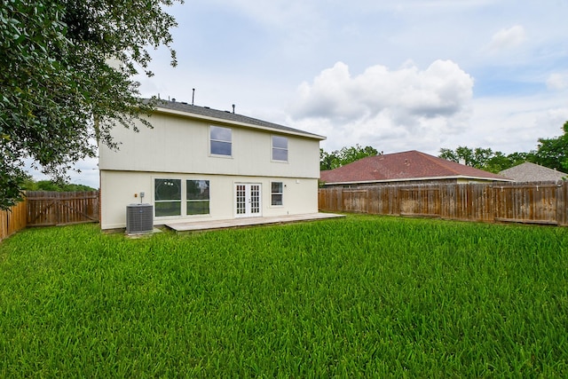 back of property with central air condition unit, a patio, a lawn, and a fenced backyard