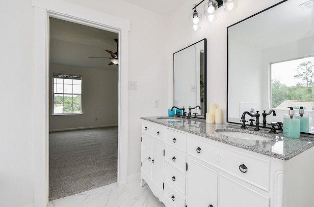 bathroom featuring a sink, ceiling fan, double vanity, and marble finish floor