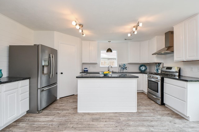 kitchen featuring wall chimney range hood, stainless steel appliances, white cabinets, and light wood finished floors