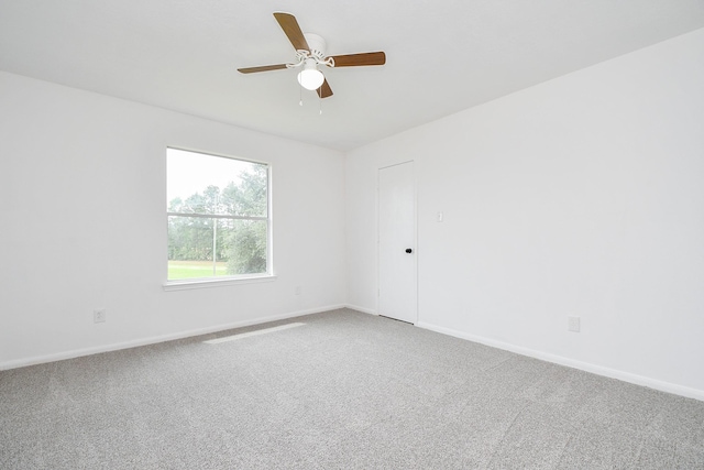 empty room with baseboards, ceiling fan, and light carpet