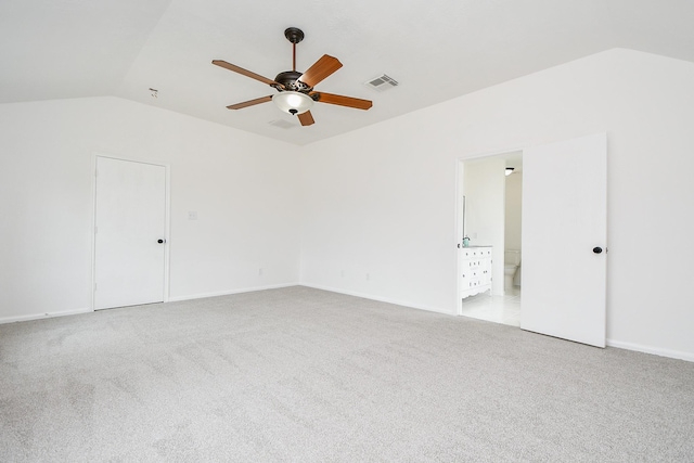 unfurnished room with visible vents, lofted ceiling, baseboards, light colored carpet, and a ceiling fan