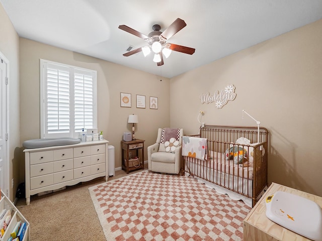 bedroom featuring a nursery area, a ceiling fan, and visible vents