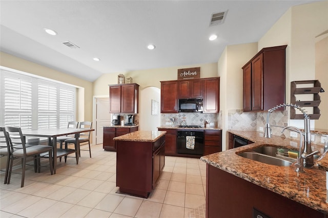 kitchen featuring a center island, backsplash, black appliances, and visible vents