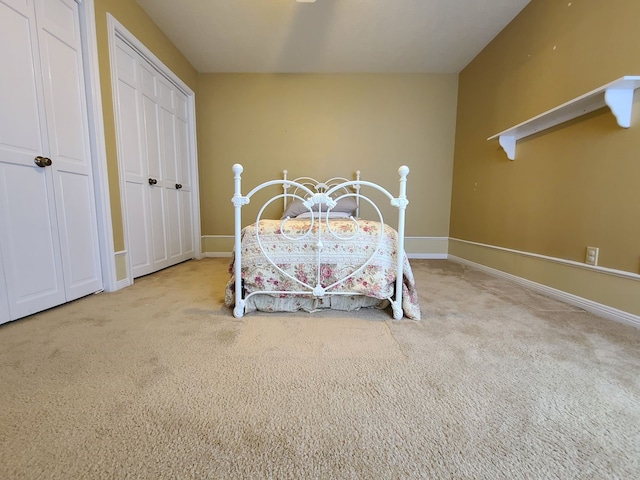 bedroom featuring multiple closets, baseboards, and carpet
