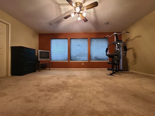 interior space with carpet flooring, a textured ceiling, ceiling fan, and baseboards