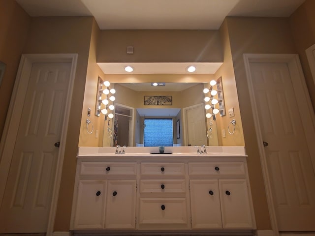 bathroom featuring double vanity, a sink, and a stall shower