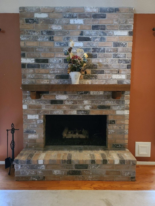 room details with baseboards, a fireplace, and wood finished floors
