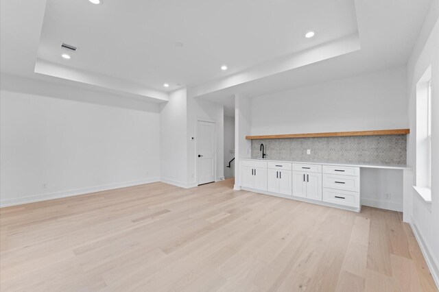 bar featuring a sink, decorative backsplash, light wood-type flooring, and recessed lighting