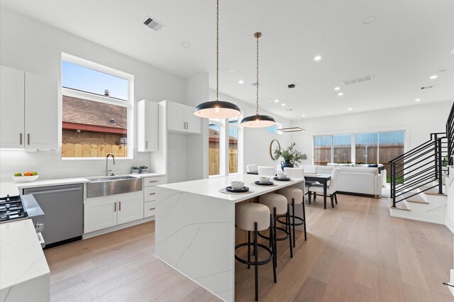 819 Dorothy St Unit A, Houston, TX 77008 - kitchen with a sink, light wood finished floors, recessed lighting, white cabinets, and healthy amount of natural light