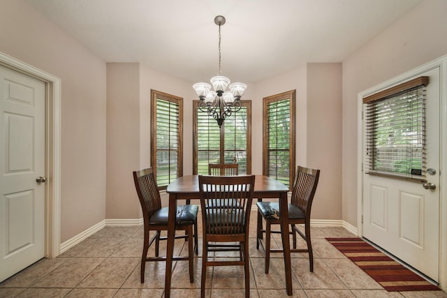 dining area featuring baseboards, a chandelier, and light tile patterned floors