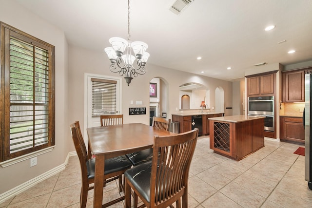 dining space featuring visible vents, an inviting chandelier, light tile patterned flooring, recessed lighting, and arched walkways