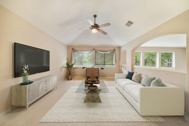 carpeted living area featuring plenty of natural light, a ceiling fan, and baseboards