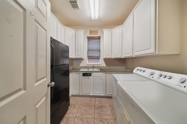 laundry area with cabinet space, light tile patterned flooring, a sink, separate washer and dryer, and visible vents