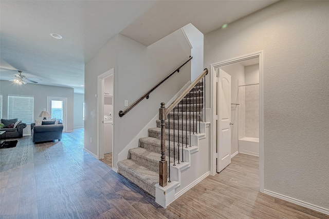15314 Stulan Burn Dr, Humble, TX 77346 - stairway with baseboards, ceiling fan, a textured wall, and wood finished floors