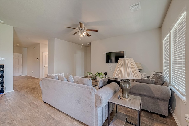15314 Stulan Burn Dr, Humble, TX 77346 - living area featuring a ceiling fan, baseboards, visible vents, and light wood-type flooring