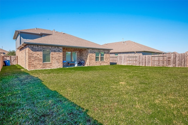 15314 Stulan Burn Dr, Humble, TX 77346 - rear view of property featuring a yard, brick siding, a shingled roof, and a fenced backyard