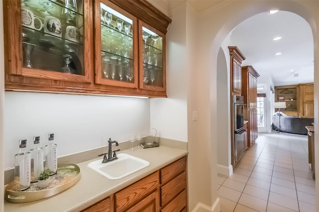 3210 Oakmont Dr, Sugar Land, TX 77479 - bar with light tile patterned flooring, indoor wet bar, recessed lighting, arched walkways, and a sink