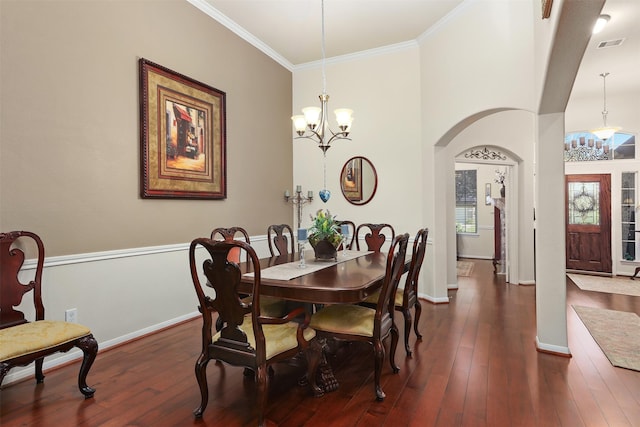 dining area with visible vents, crown molding, an inviting chandelier, arched walkways, and dark wood finished floors