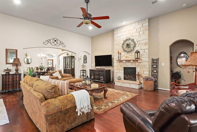living area with arched walkways, dark wood finished floors, recessed lighting, and ceiling fan with notable chandelier