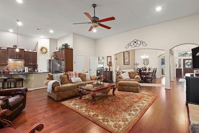 living room with visible vents, a ceiling fan, recessed lighting, dark wood-type flooring, and arched walkways