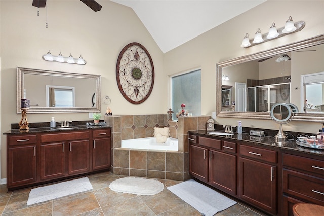 full bath with a bath, a shower stall, two vanities, a sink, and lofted ceiling