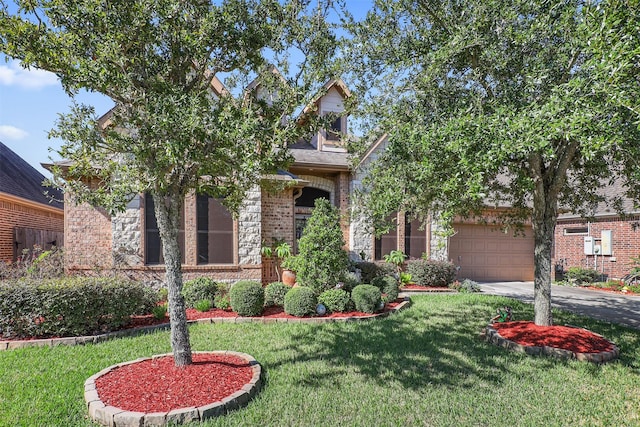 obstructed view of property with brick siding, a garage, a front yard, and aphalt driveway