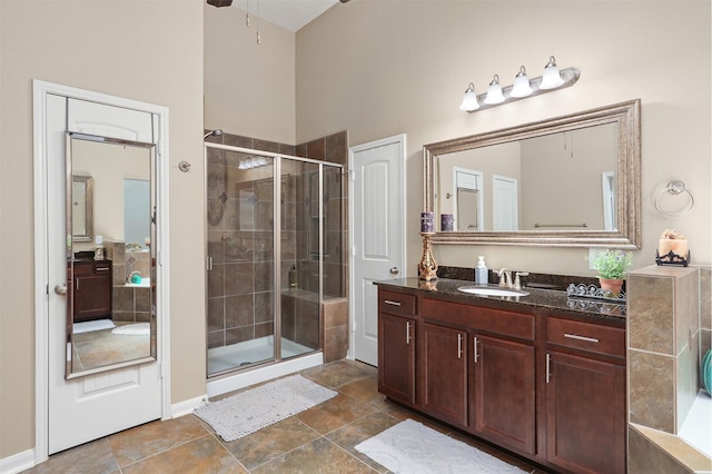 bathroom featuring vanity, baseboards, and a stall shower