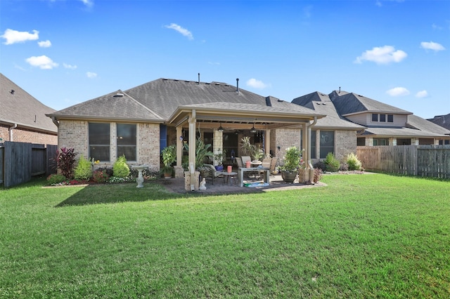 rear view of house featuring a fenced backyard, a patio, a yard, and brick siding