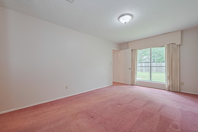 empty room with baseboards, a textured ceiling, and light carpet