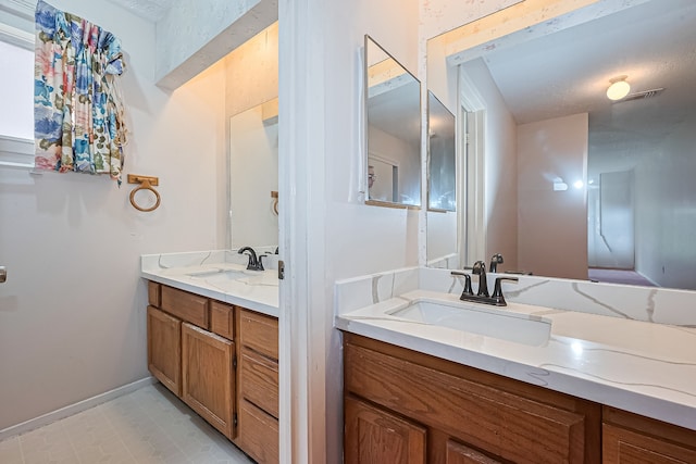 bathroom featuring vanity, baseboards, and visible vents
