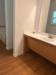 bathroom featuring vanity, baseboards, and wood finished floors