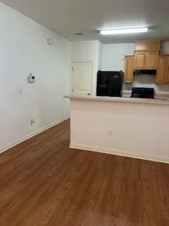 kitchen featuring fridge, baseboards, dark wood-type flooring, light countertops, and range