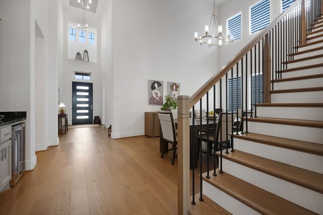 foyer with an inviting chandelier, a towering ceiling, and a wealth of natural light
