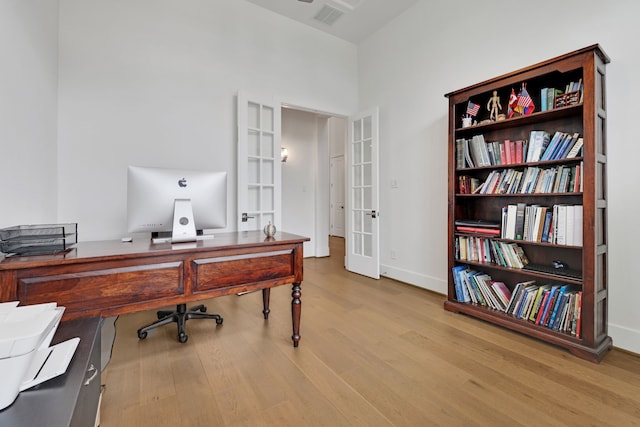 office featuring french doors, baseboards, wood finished floors, and visible vents