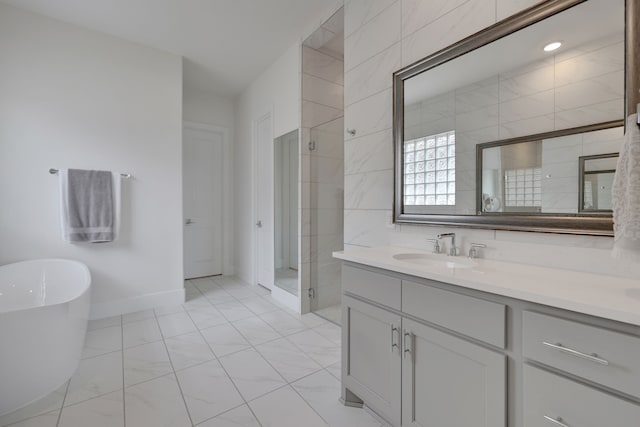 full bathroom featuring a freestanding bath, vanity, baseboards, and a shower stall