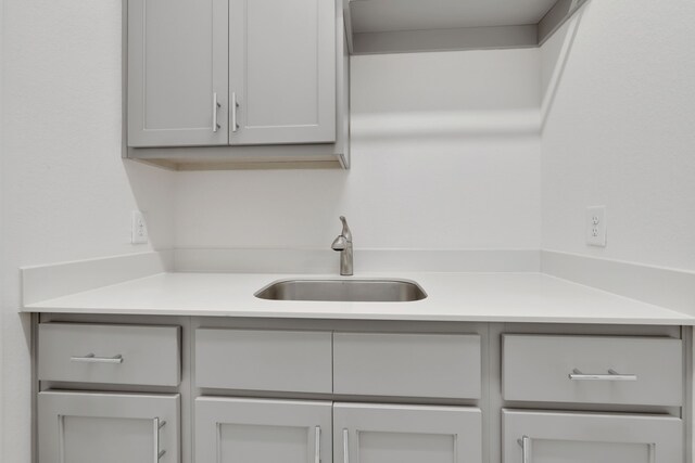 interior space with light countertops, gray cabinetry, and a sink