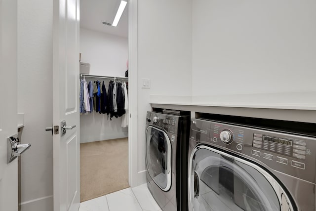 laundry area with laundry area, washing machine and dryer, visible vents, and light carpet