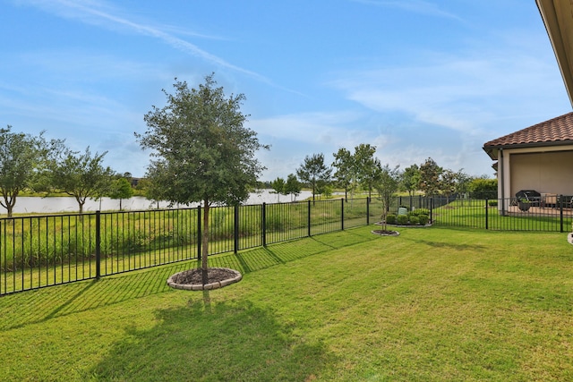 view of yard featuring a fenced backyard and a water view
