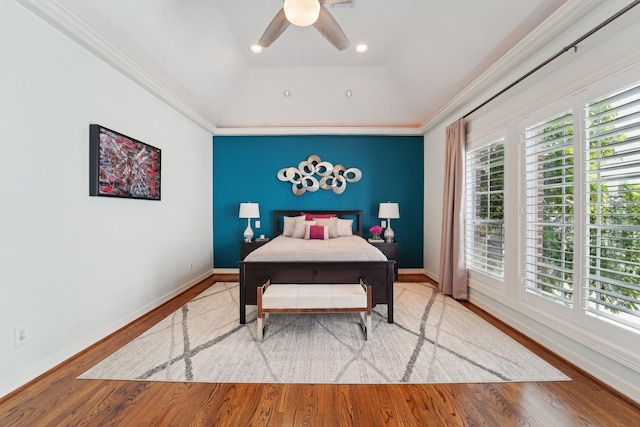 bedroom featuring ceiling fan, wood finished floors, baseboards, lofted ceiling, and ornamental molding