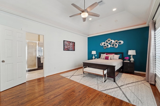 bedroom featuring vaulted ceiling, ornamental molding, and wood finished floors