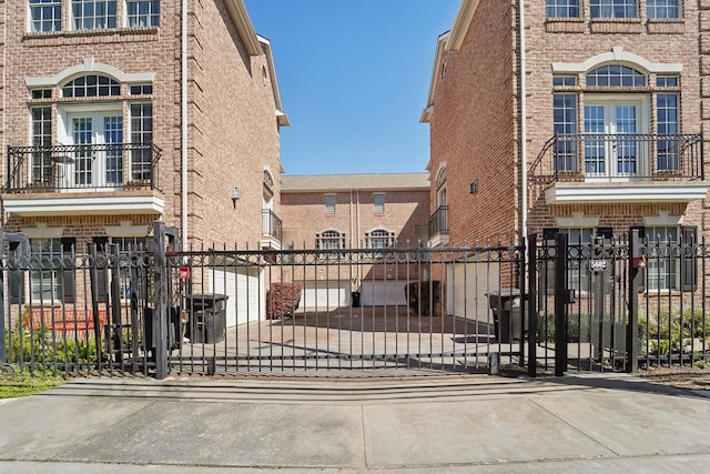 view of gate with a fenced front yard and french doors