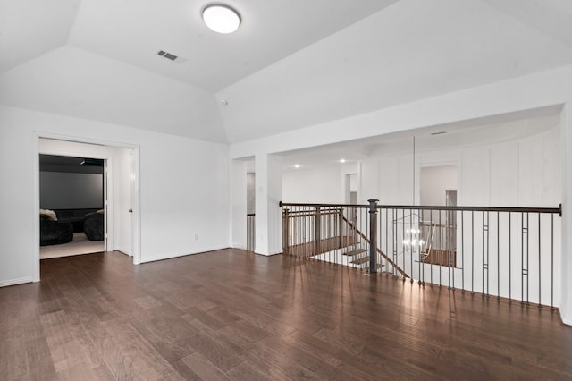 spare room featuring baseboards, high vaulted ceiling, visible vents, and wood finished floors