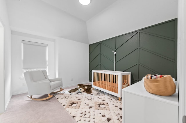 bedroom with light colored carpet, a crib, and baseboards