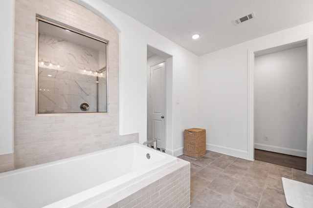 full bath featuring walk in shower, baseboards, a garden tub, and visible vents