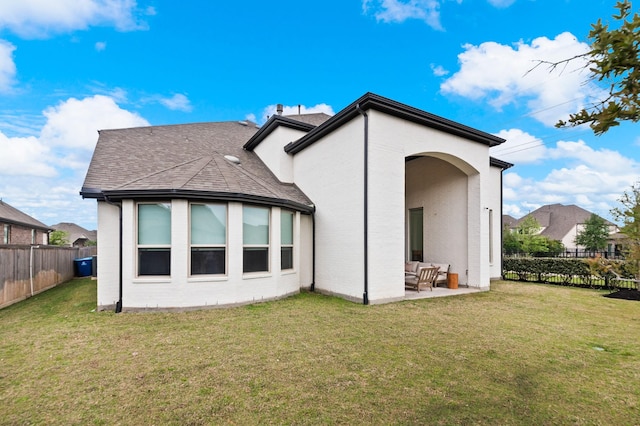 rear view of property featuring an outdoor living space, a lawn, a fenced backyard, a patio, and a shingled roof