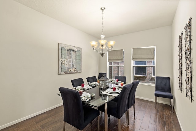 dining area with baseboards, a notable chandelier, and dark wood finished floors